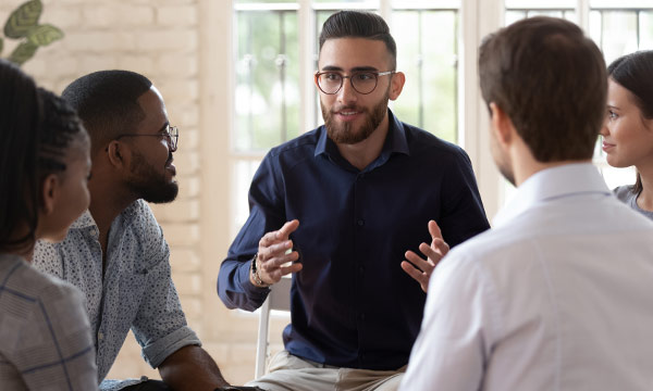 Gruppentherapiesitzung mit verschiedenen Teilnehmern im Kreis